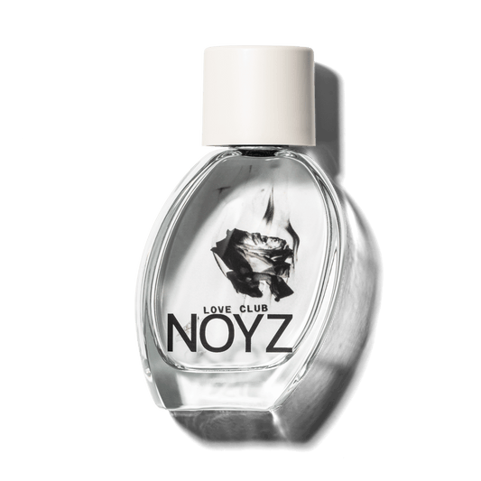 A slightly leaning, glass bottle of Noyz Love Club, a sustainably crafted, fresh perfume
