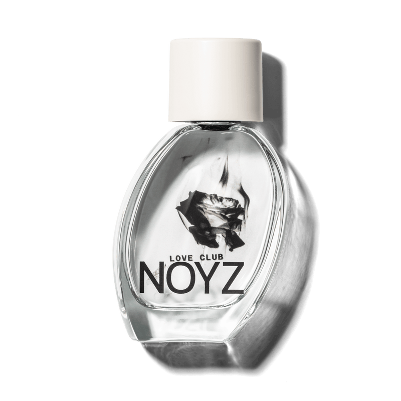 A slightly leaning, glass bottle of NOYZ Love Club, a sustainably crafted, fresh perfume