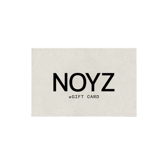 A NOYZ gift card for purchasing top unisex fragrances made of textured beige paper sits on a light beige background