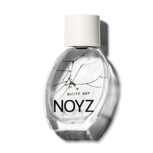 A bottle of NOYZ perfume Sh**ty Day with scent notes of amber and sage. Discover the best summer scents.